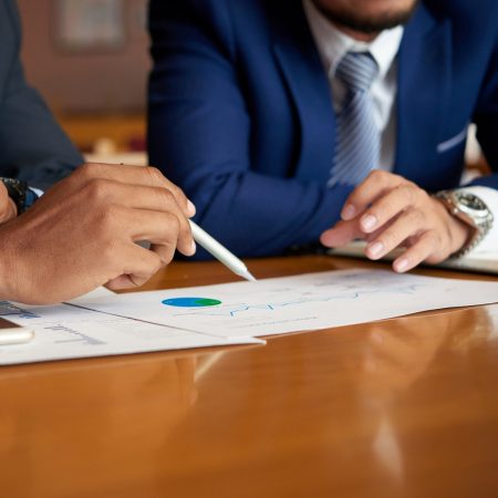 Close-up image of business people discussing financial data at meeting